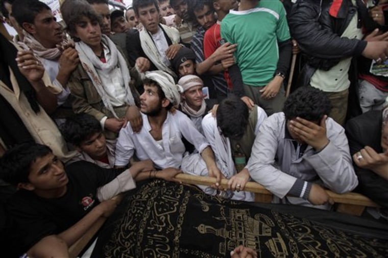 Yemeni relatives of Ahmad Saleh gather around his body during his funeral procession at the site of a demonstration demanding the resignation of Yemeni President Ali Abdullah Saleh, in Sanaa, Yemen, on Sunday. A Gulf official says the signing ceremony of a deal to end Yemen's political crisis has been indefinitely postponed, signaling the possible collapse of the agreement.